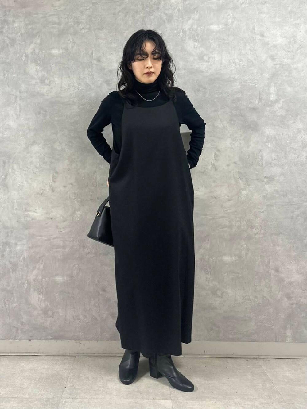 ブラック系のブーツ、ブラック系のTシャツ/カットソー、ブラック系のショルダーバッグを着用したレディースの冬コーディネートの4枚目の写真