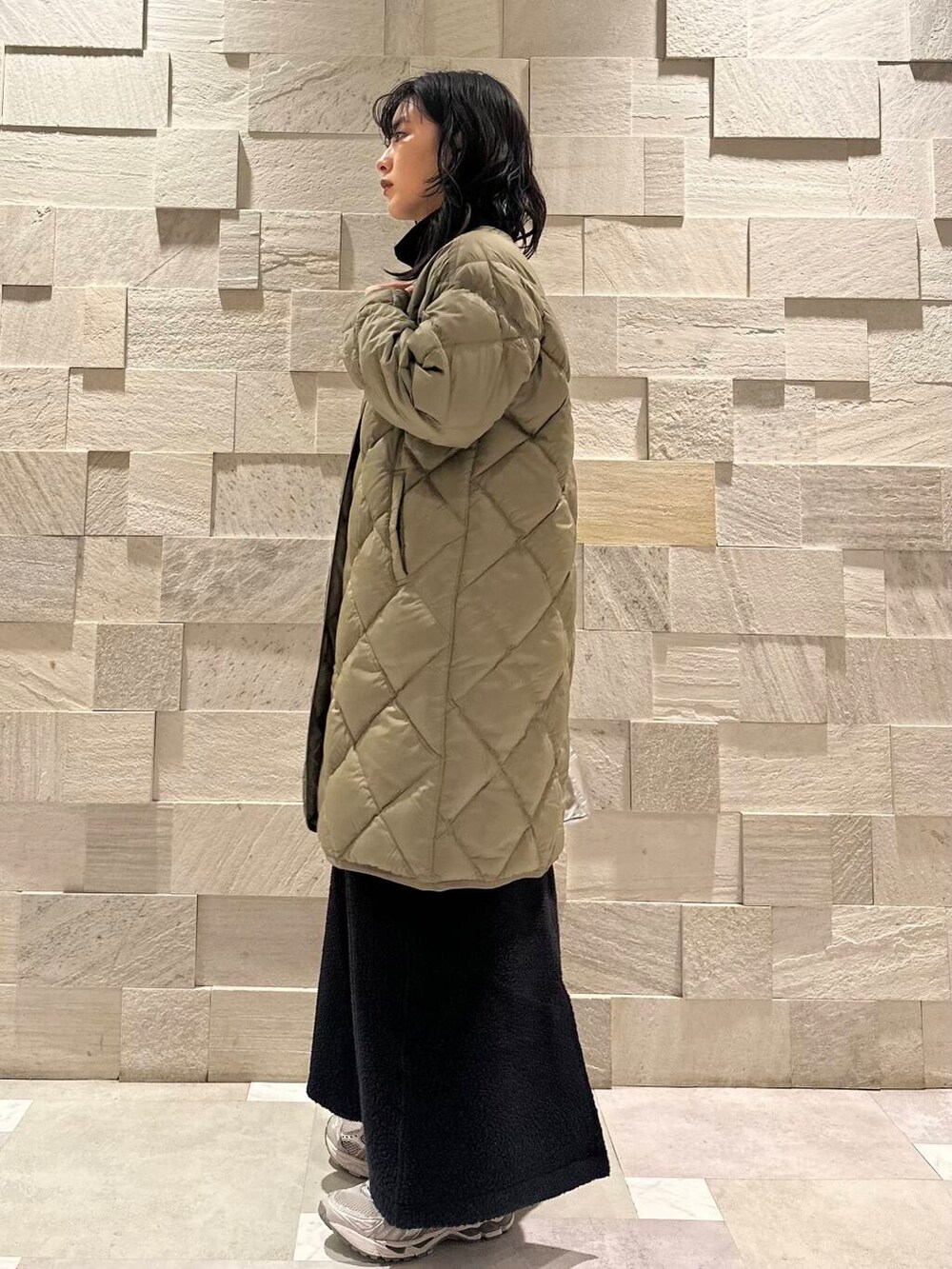 グリーン系のダウンジャケット/コート、ブラック系のスウェット、シルバー系のショルダーバッグを着用したレディースの秋コーディネートの3枚目の写真