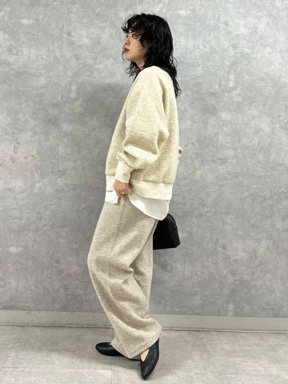 ブラック系のショルダーバッグ、ベージュ系のその他パンツ、ベージュ系のTシャツ/カットソーを着用したレディースの冬コーディネートの3枚目の写真