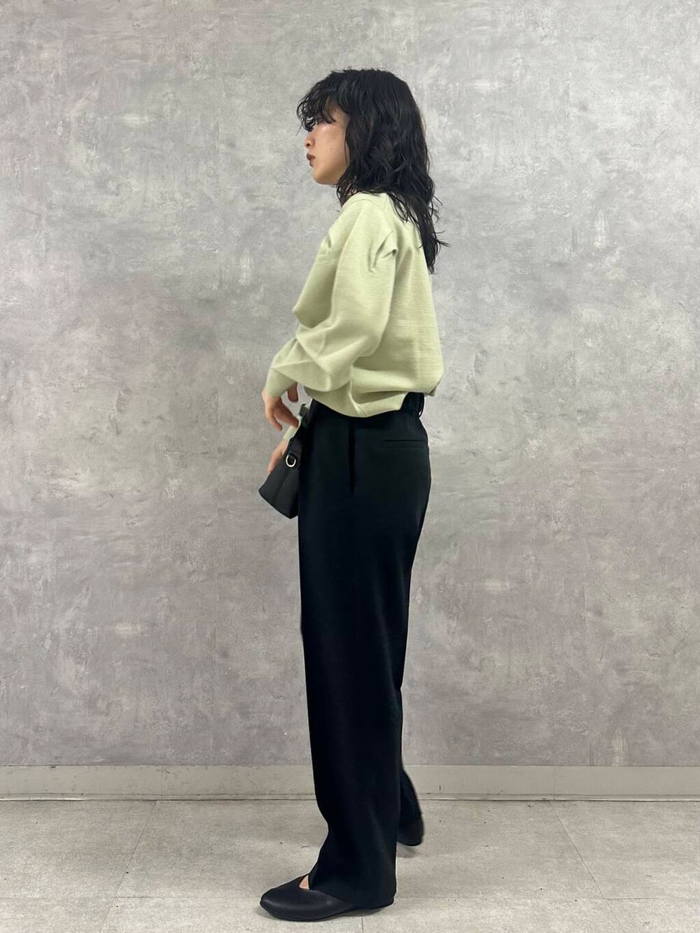 グリーン系のニット/セーター、ブラック系のパンプス、グレー系のダウンジャケット/コートを着用したレディースの冬コーディネートの3枚目の写真