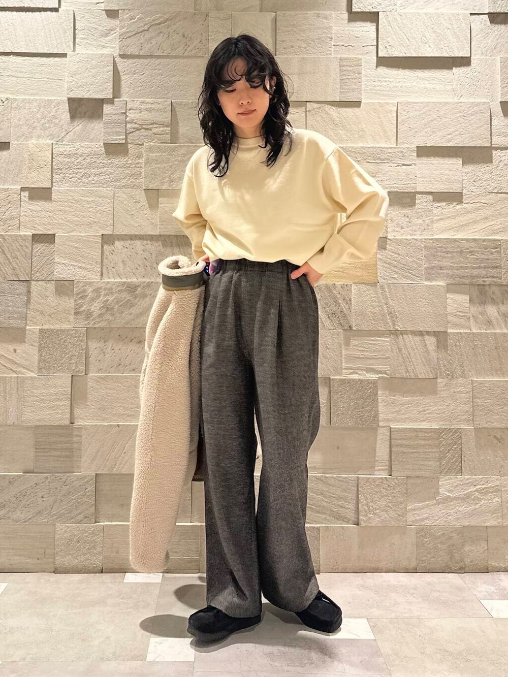 ブラック系のブーツ、グレー系のその他パンツ、ホワイト系のニット/セーターを着用したレディースの冬コーディネートの3枚目の写真