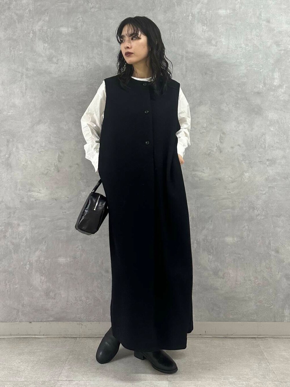 ブラック系のショルダーバッグ、グレー系のステンカラーコート、ホワイト系のシャツ/ブラウスを着用したレディースの冬コーディネートの5枚目の写真