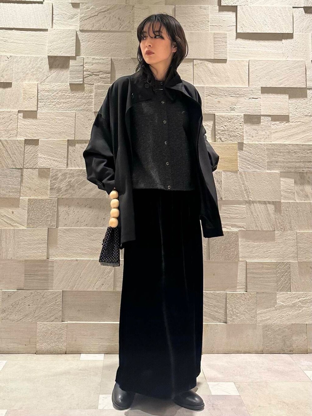 ブラック系のその他アウター、ブラック系のスカート、グレー系のカーディガン/ボレロを着用したレディースの冬コーディネートの3枚目の写真