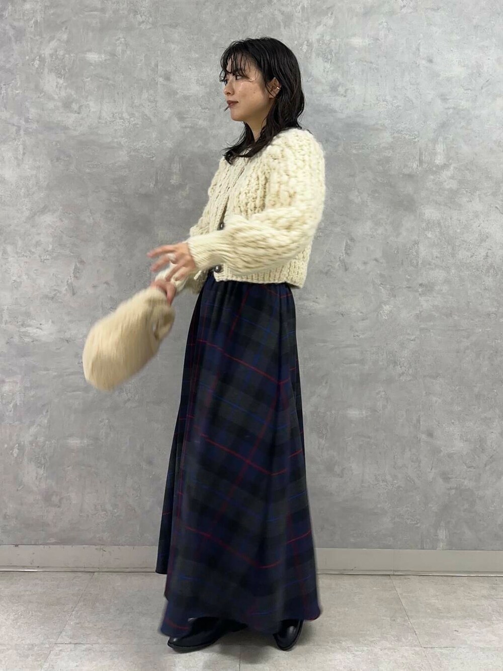 ホワイト系のカーディガン/ボレロ、ブラック系のブーツ、ブルー系のスカートを着用したレディースの冬コーディネートの3枚目の写真