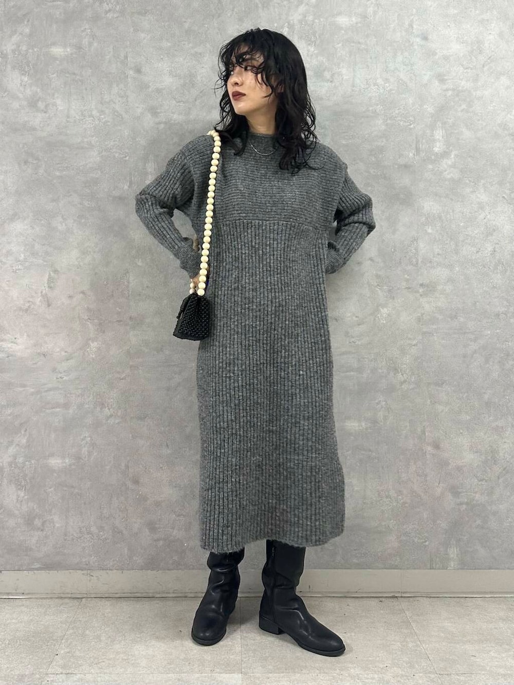 ホワイト系のダウンジャケット/コート、グレー系のワンピース、ブラック系のショルダーバッグを着用したレディースの冬コーディネートの4枚目の写真