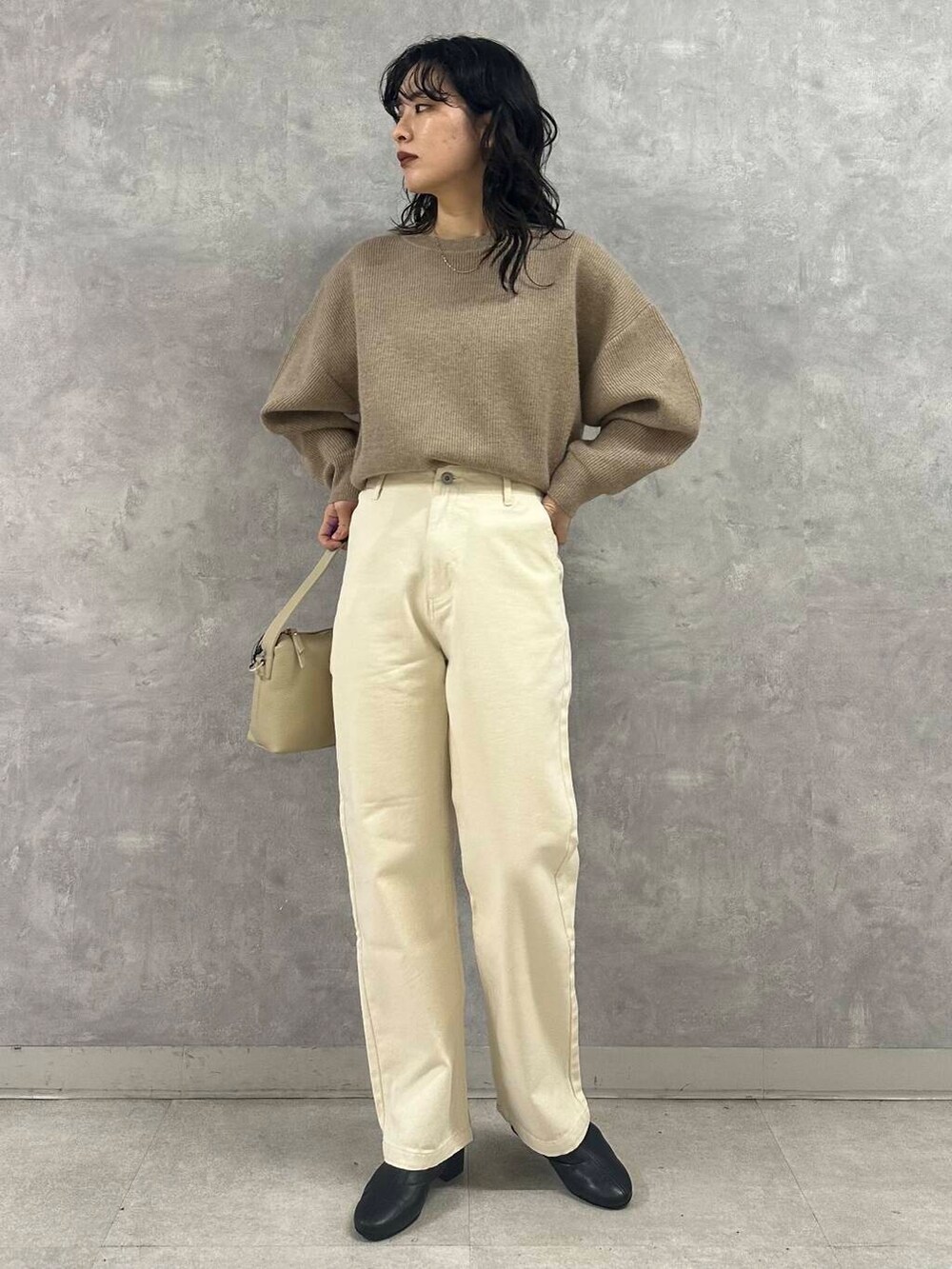 ブラック系のブーツ、ホワイト系のダウンジャケット/コート、ベージュ系のデニムパンツを着用したレディースの冬コーディネートの3枚目の写真