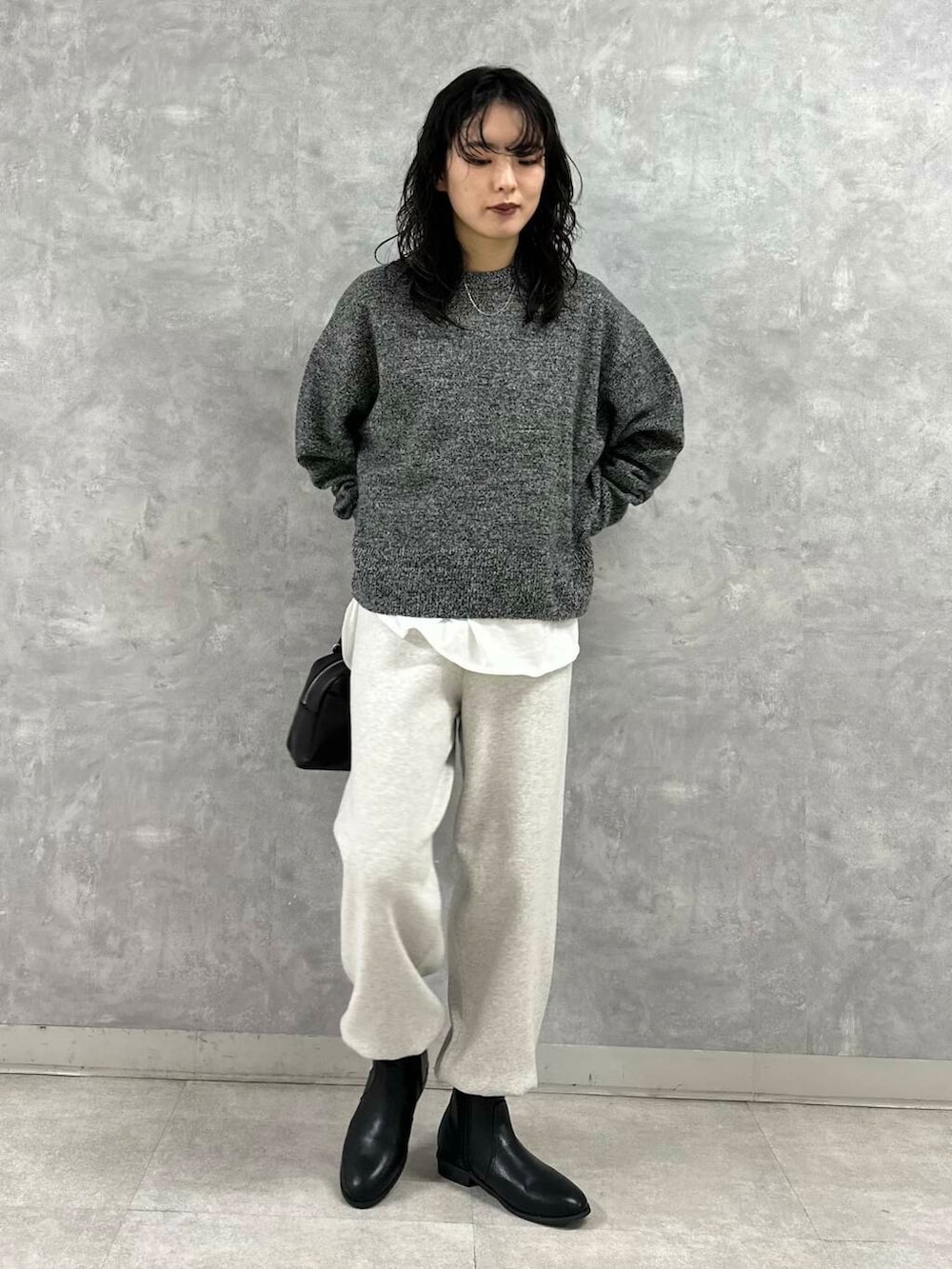 ブラック系のショルダーバッグ、ブラック系のブーツ、ホワイト系のTシャツ/カットソーを着用したレディースの冬コーディネートの4枚目の写真