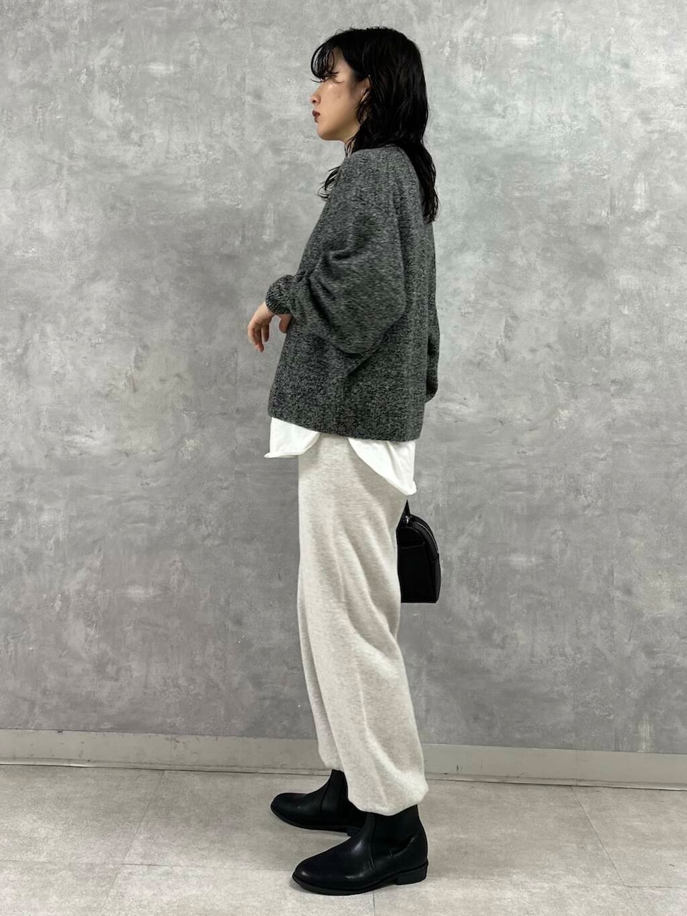 ブラック系のショルダーバッグ、ブラック系のブーツ、ホワイト系のTシャツ/カットソーを着用したレディースの冬コーディネートの7枚目の写真