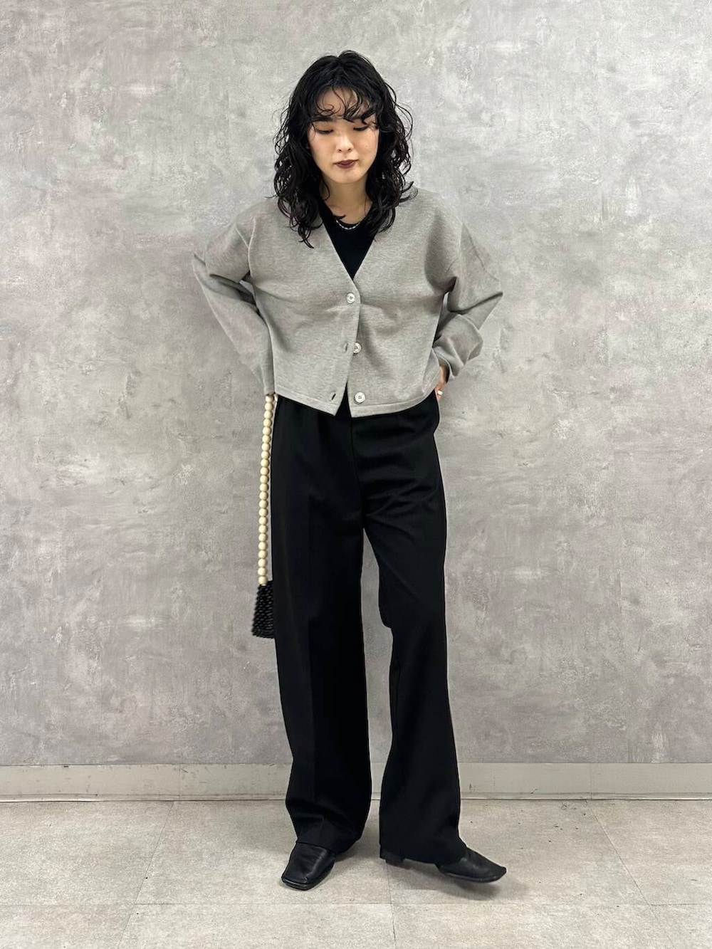 ブラック系のその他パンツ、グレー系のカーディガン/ボレロ、ブラック系のショルダーバッグを着用したレディースの冬コーディネートの3枚目の写真