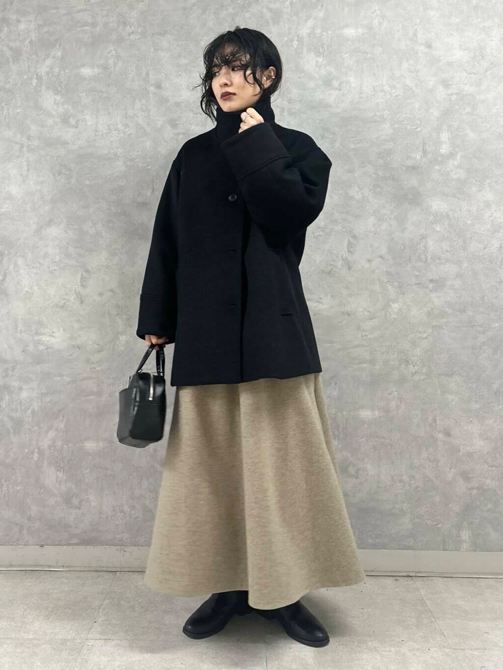 ブルー系のその他アウター、ブラック系のショルダーバッグ、ブラック系のニット/セーターを着用したレディースの冬コーディネートの2枚目の写真