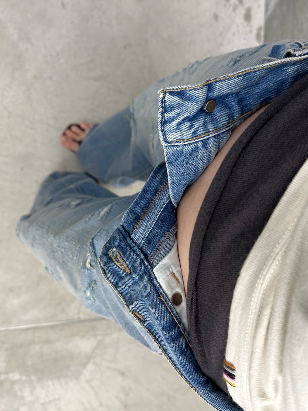 ホワイト系のキャミソール、グレー系のタンクトップ、ブルー系のデニムパンツを着用したレディースの夏コーディネートの3枚目の写真