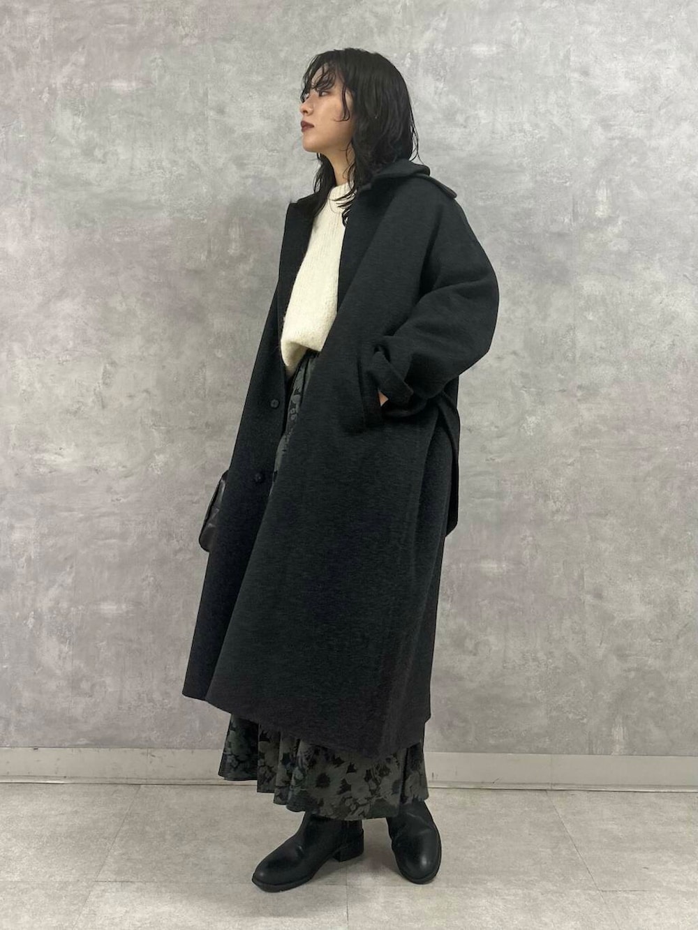 ホワイト系のニット/セーター、ブラック系のスカート、ブラック系のショルダーバッグを着用したレディースの冬コーディネートの4枚目の写真