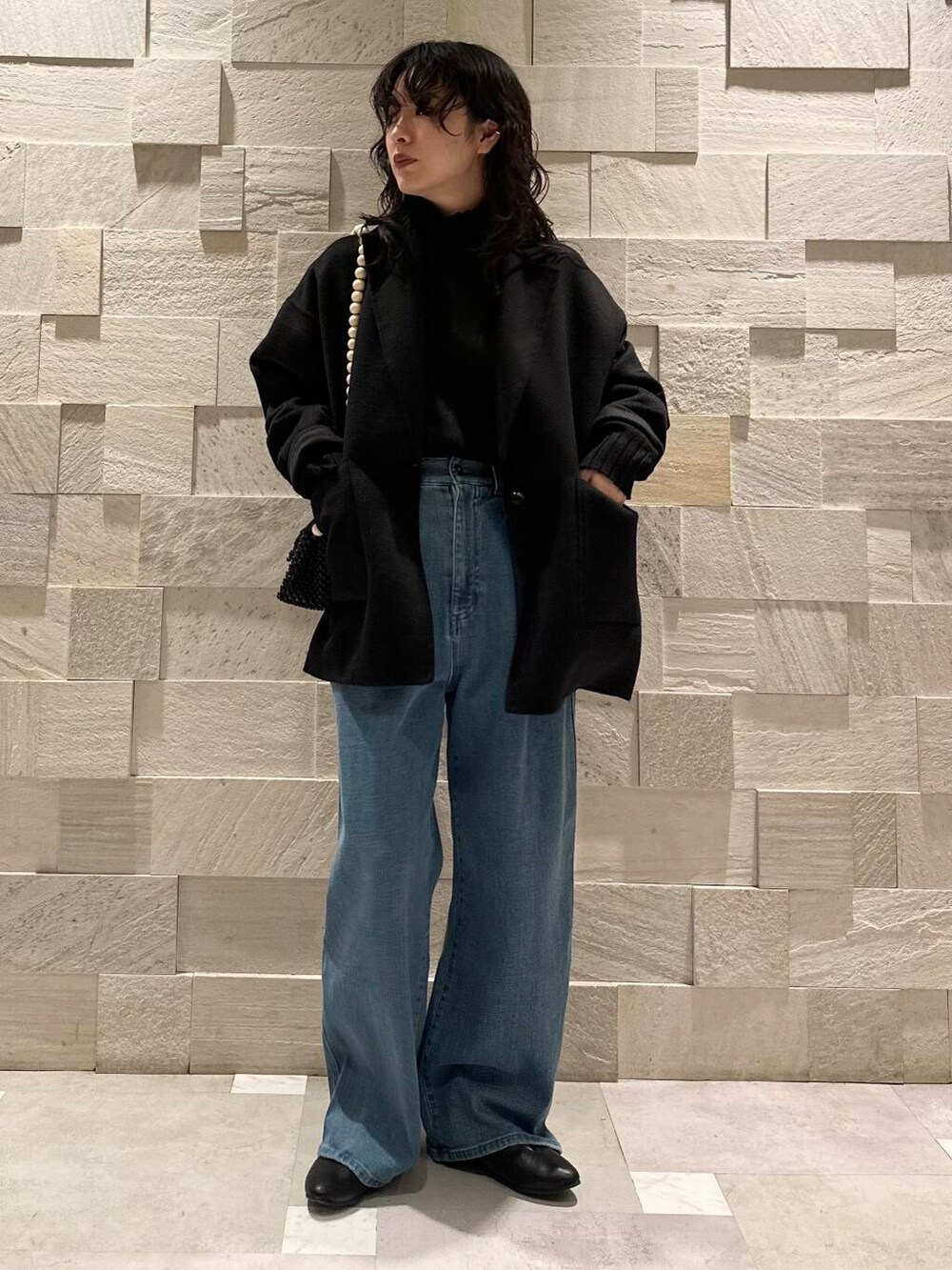 ブラック系のその他アウター、ブラック系のパンプス、ブラック系のニット/セーターを着用したレディースの冬コーディネートの2枚目の写真