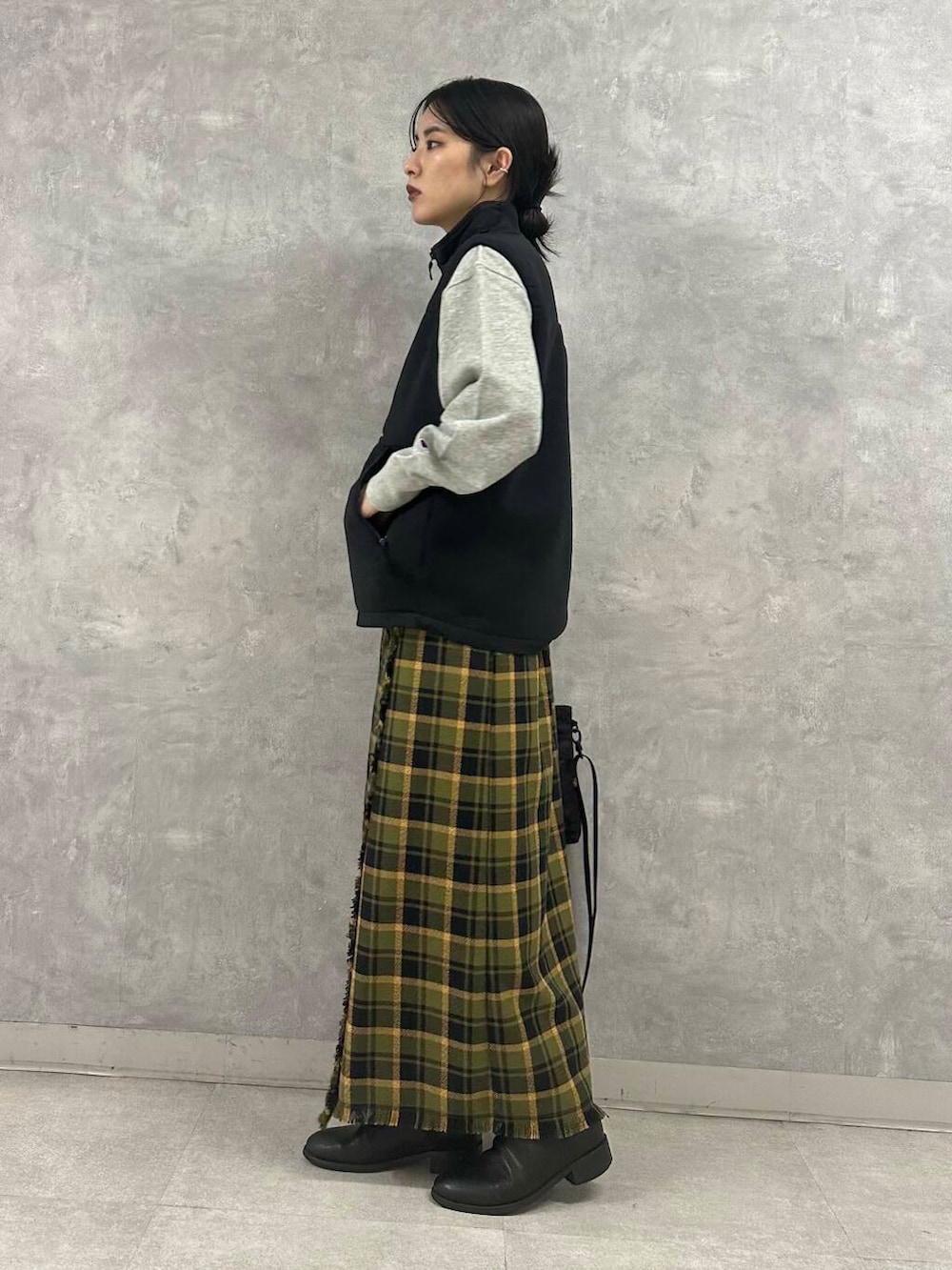 ブラック系のショルダーバッグ、グリーン系のスカート、グレー系のTシャツ/カットソーを着用したレディースの秋コーディネートの3枚目の写真