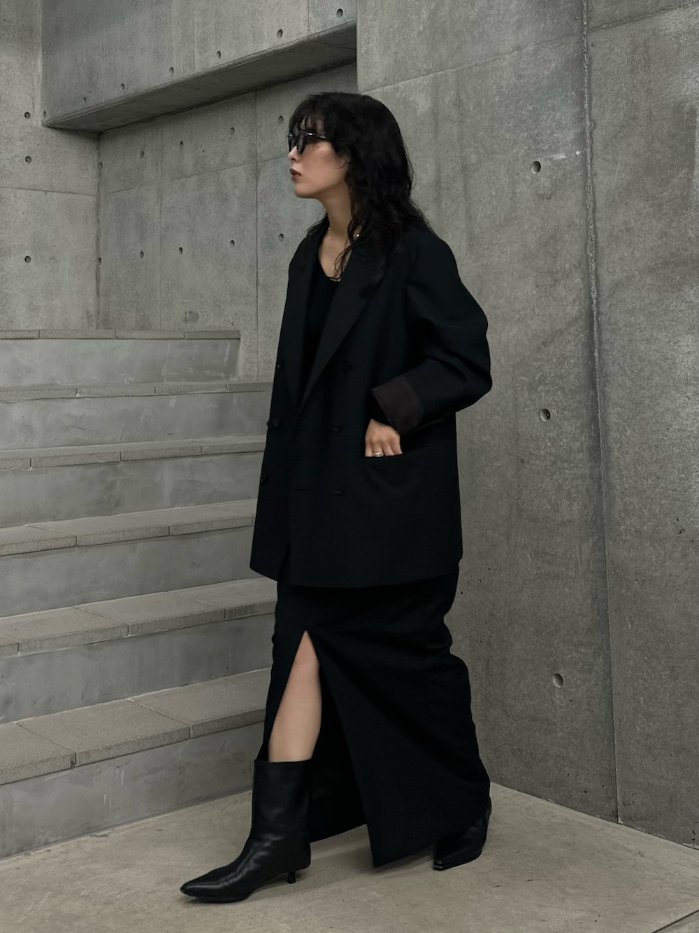 ブラック系のその他アウター、ブラック系のスカート、ブラック系のブーツを着用したレディースの秋コーディネートの3枚目の写真