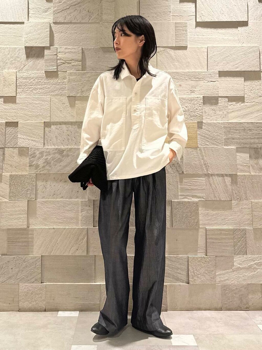 ブラック系のトートバッグ、ブラック系のパンプス、ブルー系のデニムパンツを着用したレディースの秋コーディネートの2枚目の写真