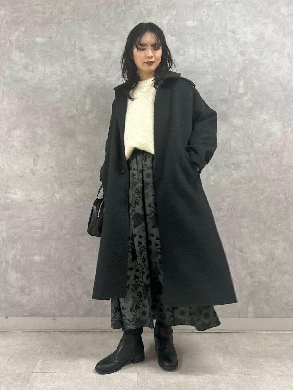 ホワイト系のニット/セーター、ブラック系のスカート、ブラック系のショルダーバッグを着用したレディースの冬コーディネートの3枚目の写真