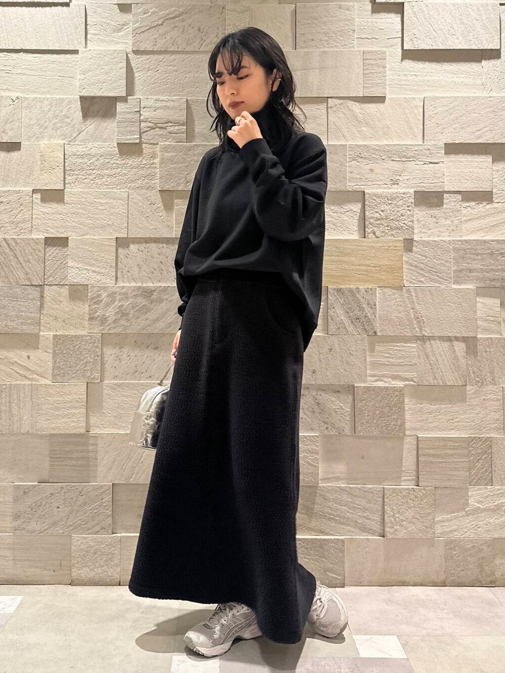 グリーン系のダウンジャケット/コート、ブラック系のスウェット、シルバー系のショルダーバッグを着用したレディースの秋コーディネートの7枚目の写真