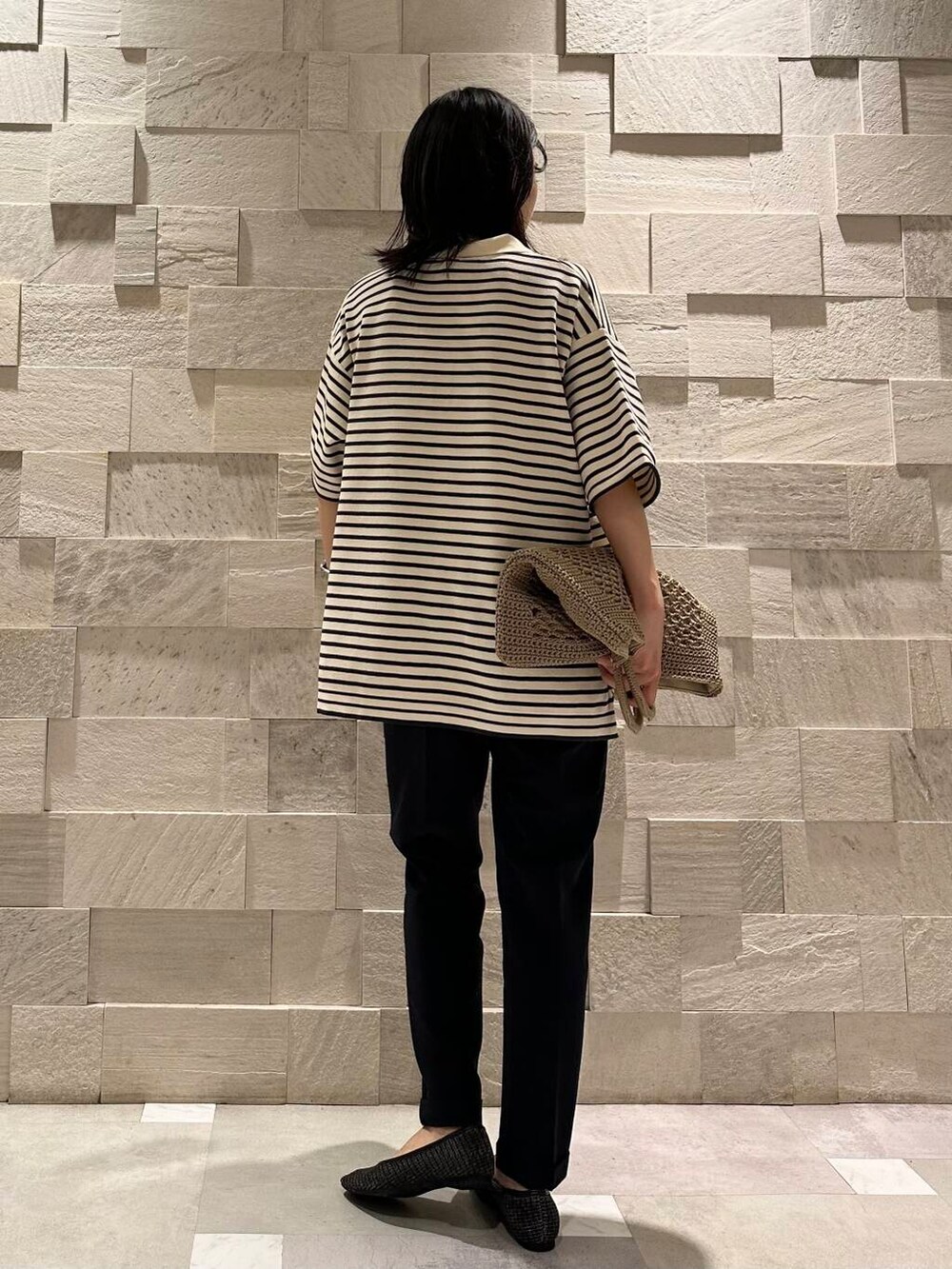 ブラック系のパンプス、グレー系のトートバッグ、ホワイト系のニット/セーターを着用したレディースの夏コーディネートの3枚目の写真