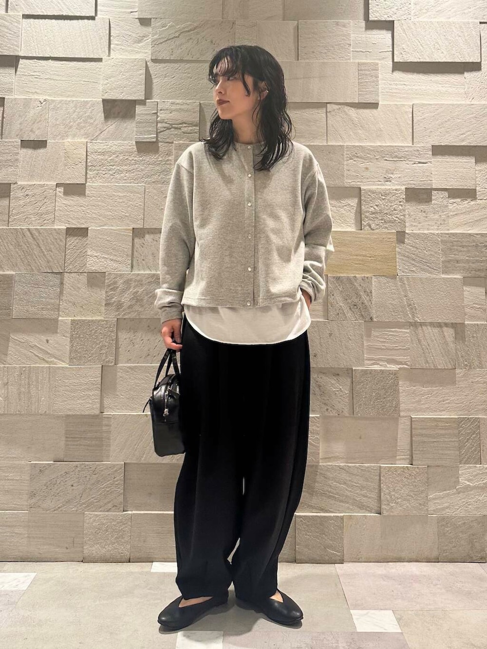 ブラック系のパンプス、ホワイト系のTシャツ/カットソー、ブラック系のショルダーバッグを着用したレディースの冬コーディネートの2枚目の写真