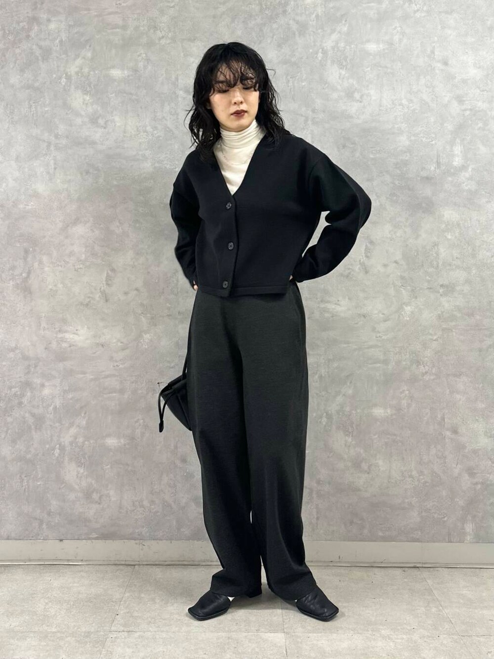 ホワイト系のTシャツ/カットソー、ブラック系のカーディガン/ボレロ、グレー系のその他パンツを着用したレディースの冬コーディネートの2枚目の写真