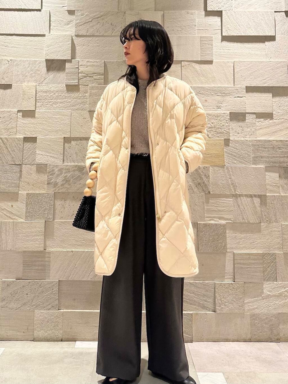 ホワイト系のダウンジャケット/コート、ブラック系のパンプス、グレー系のその他パンツを着用したレディースの冬コーディネートの4枚目の写真