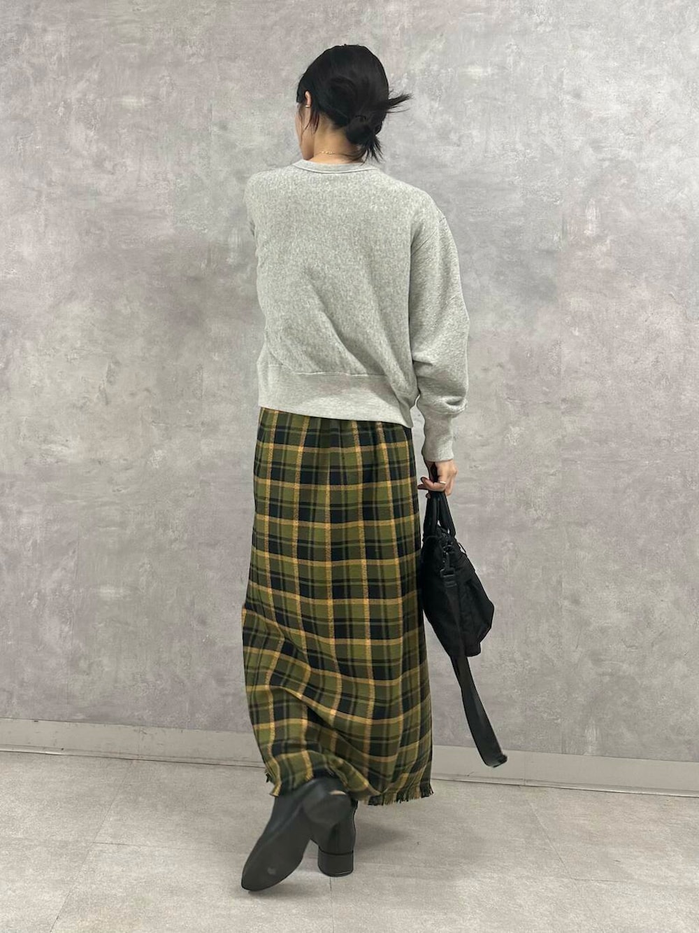 ブラック系のショルダーバッグ、グリーン系のスカート、グレー系のTシャツ/カットソーを着用したレディースの秋コーディネートの5枚目の写真