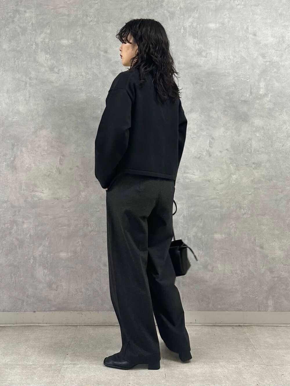 ホワイト系のTシャツ/カットソー、ブラック系のカーディガン/ボレロ、グレー系のその他パンツを着用したレディースの冬コーディネートの4枚目の写真