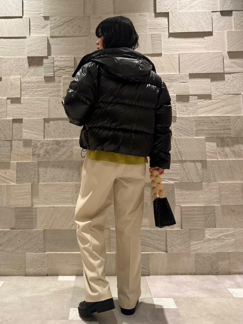 ブラック系のブーツ、ホワイト系のその他パンツ、ブラック系のダウンジャケット/コートを着用したレディースの冬コーディネートの3枚目の写真