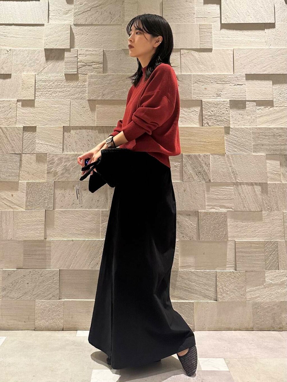 ブラック系のパンプス、ブラック系のトートバッグ、レッド系のニット/セーターを着用したレディースの秋コーディネートの2枚目の写真