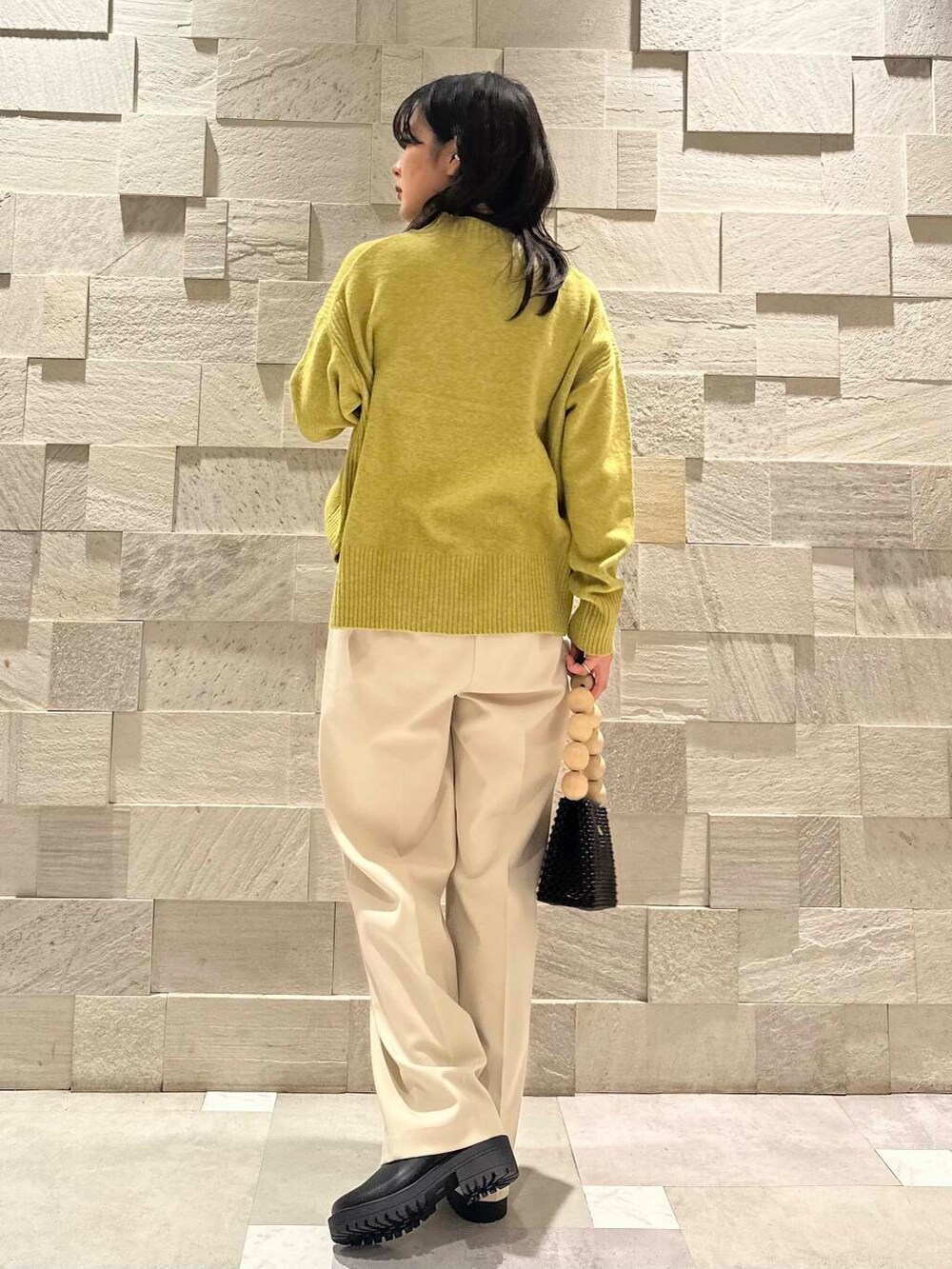 ブラック系のブーツ、ホワイト系のその他パンツ、ブラック系のダウンジャケット/コートを着用したレディースの冬コーディネートの6枚目の写真