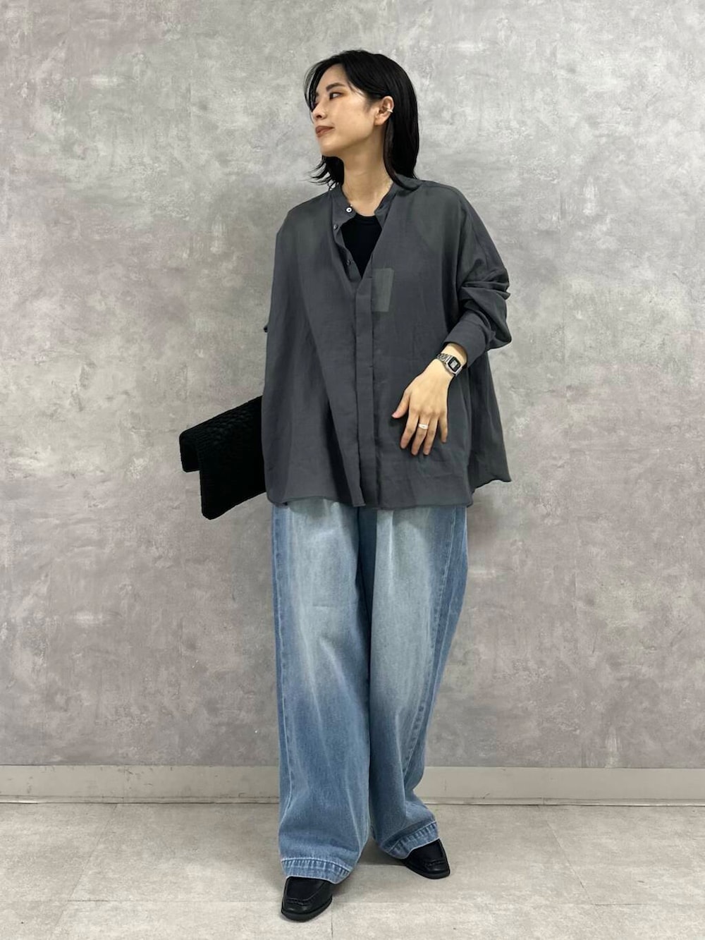 ブラック系のサンダル、ブルー系のデニムパンツ、ブラック系のトートバッグを着用したレディースの夏コーディネートの3枚目の写真