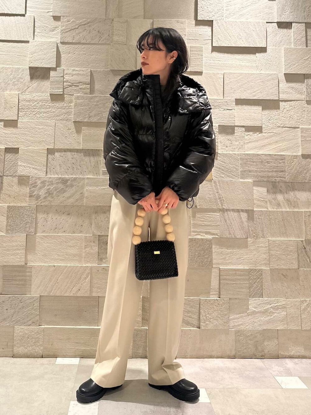 ブラック系のブーツ、ホワイト系のその他パンツ、ブラック系のダウンジャケット/コートを着用したレディースの冬コーディネートの4枚目の写真