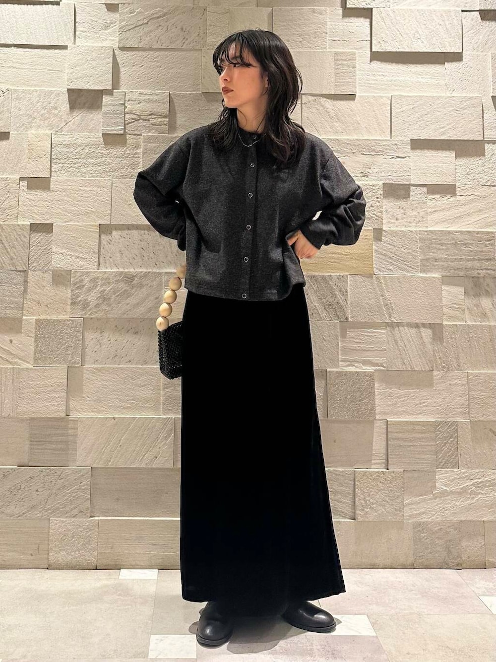 ブラック系のその他アウター、ブラック系のスカート、グレー系のカーディガン/ボレロを着用したレディースの冬コーディネートの4枚目の写真