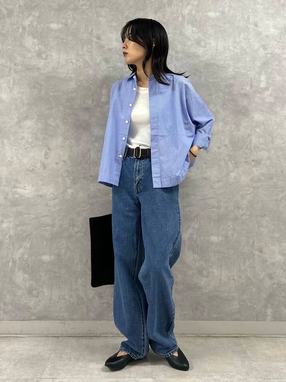 ホワイト系のタンクトップ、ブルー系のデニムパンツ、ブラック系のトートバッグを着用したレディースの夏コーディネートの3枚目の写真