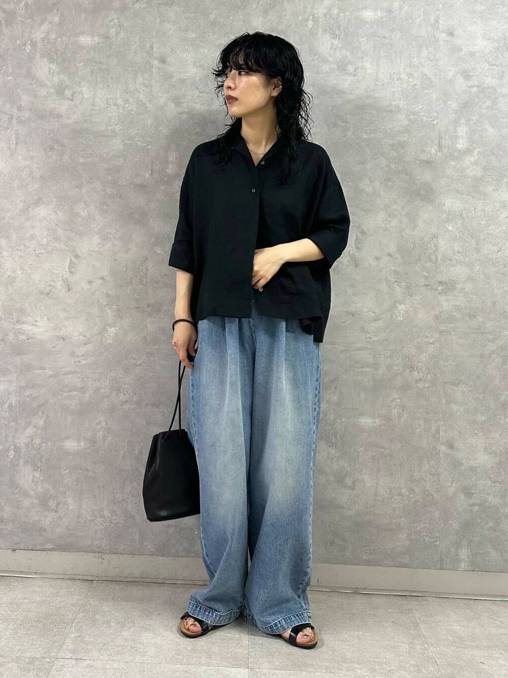 ブルー系のデニムパンツ、ブラック系のシャツ/ブラウス、ブラック系のサンダルを着用したレディースの夏コーディネートの4枚目の写真