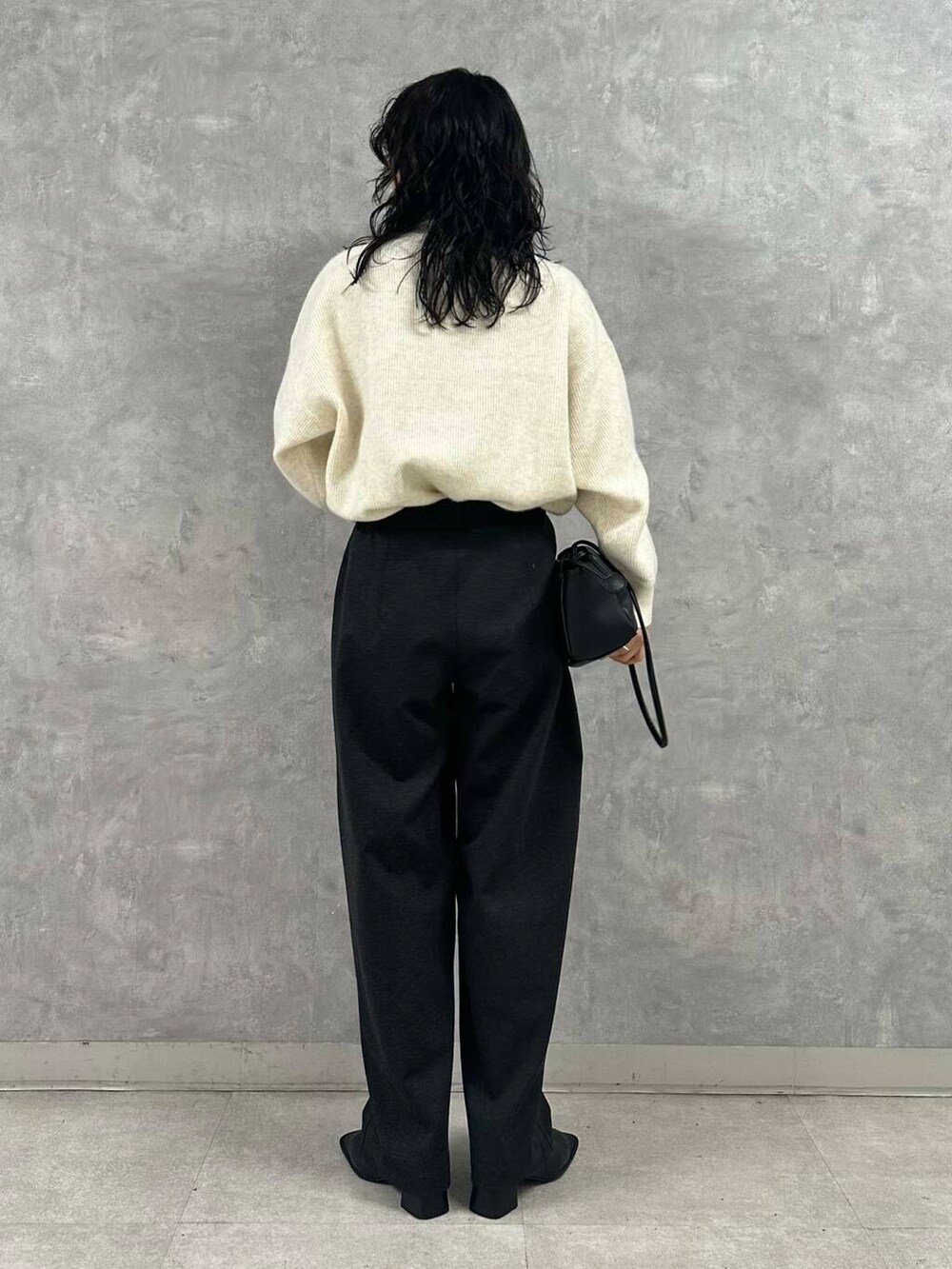 ホワイト系のTシャツ/カットソー、ブラック系のショルダーバッグ、ホワイト系のニット/セーターを着用したレディースの冬コーディネートの2枚目の写真