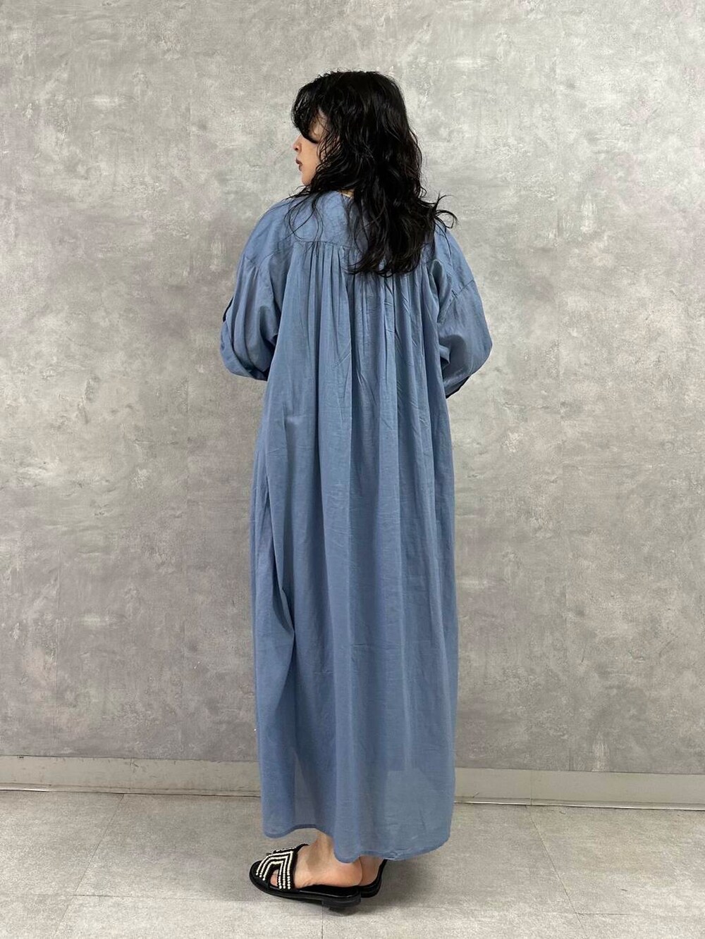 ブラック系のハンドバッグ、ブルー系のワンピース、ブラック系のサンダルを着用したレディースの夏コーディネートの3枚目の写真