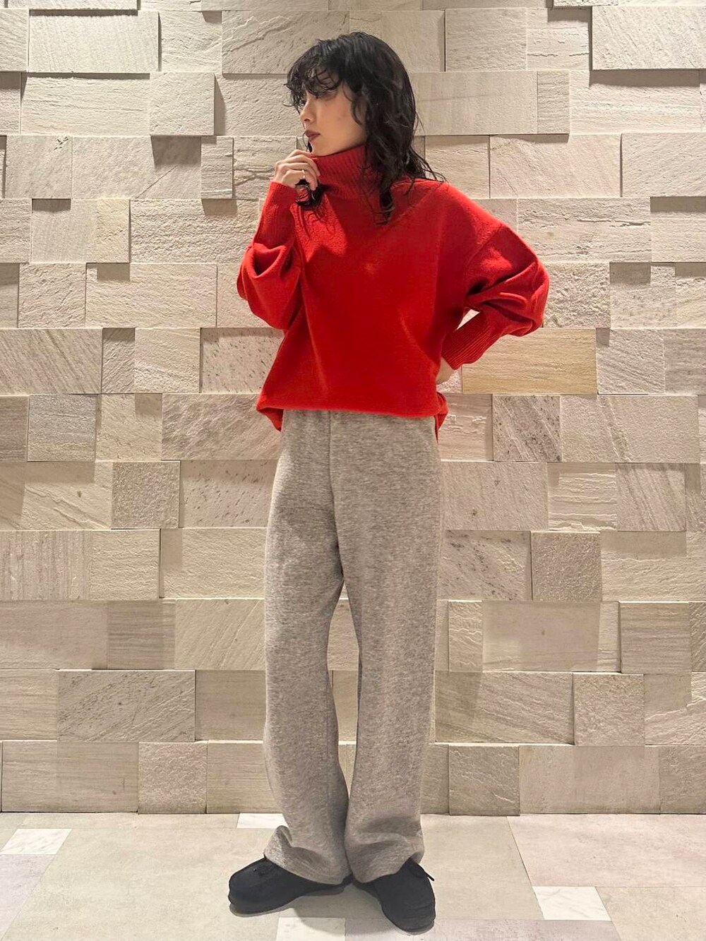 ブラック系のブーツ、グレー系のその他パンツ、レッド系のニット/セーターを着用したレディースの冬コーディネートの2枚目の写真