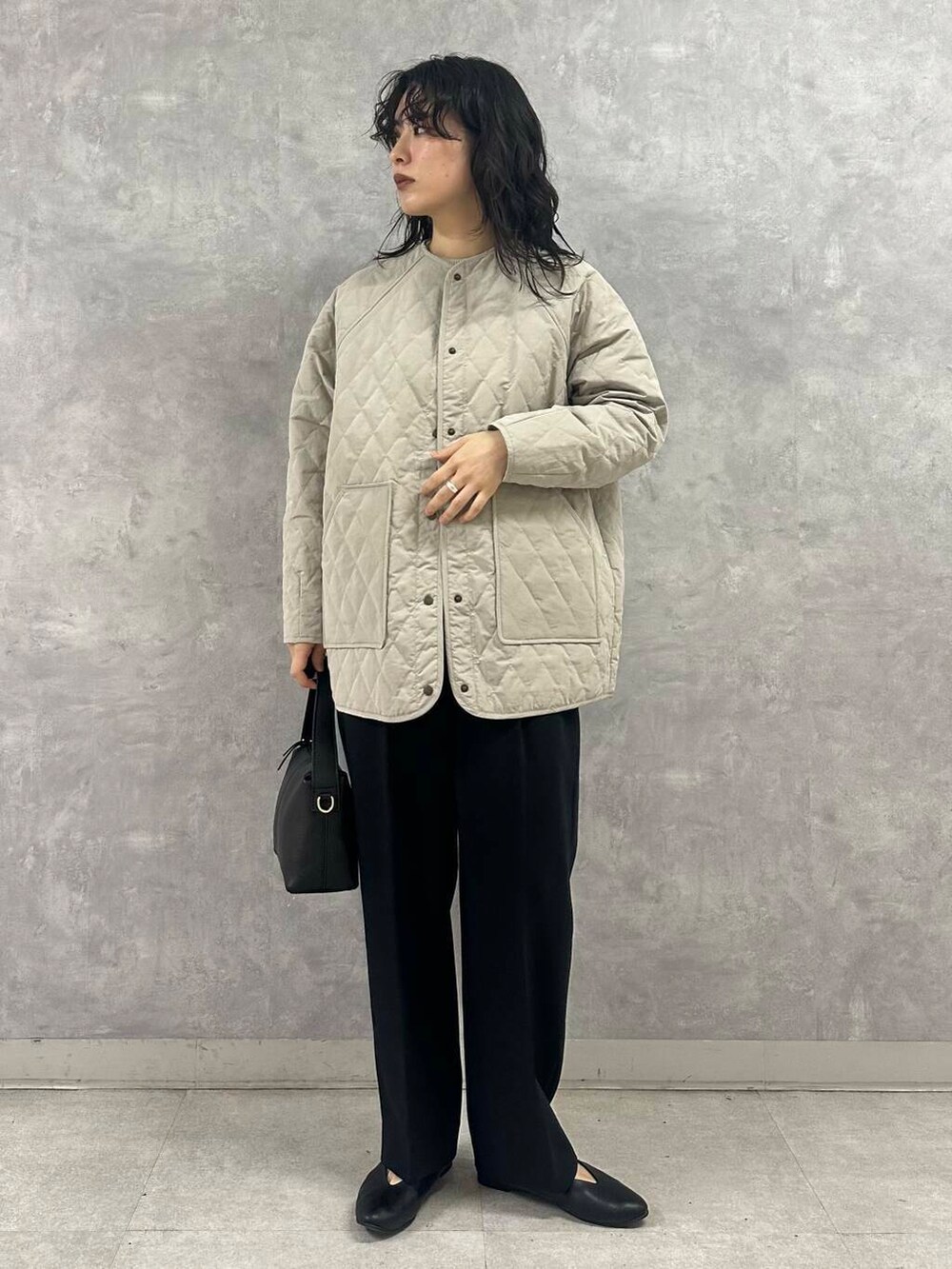 グリーン系のニット/セーター、ブラック系のパンプス、グレー系のダウンジャケット/コートを着用したレディースの冬コーディネートの4枚目の写真