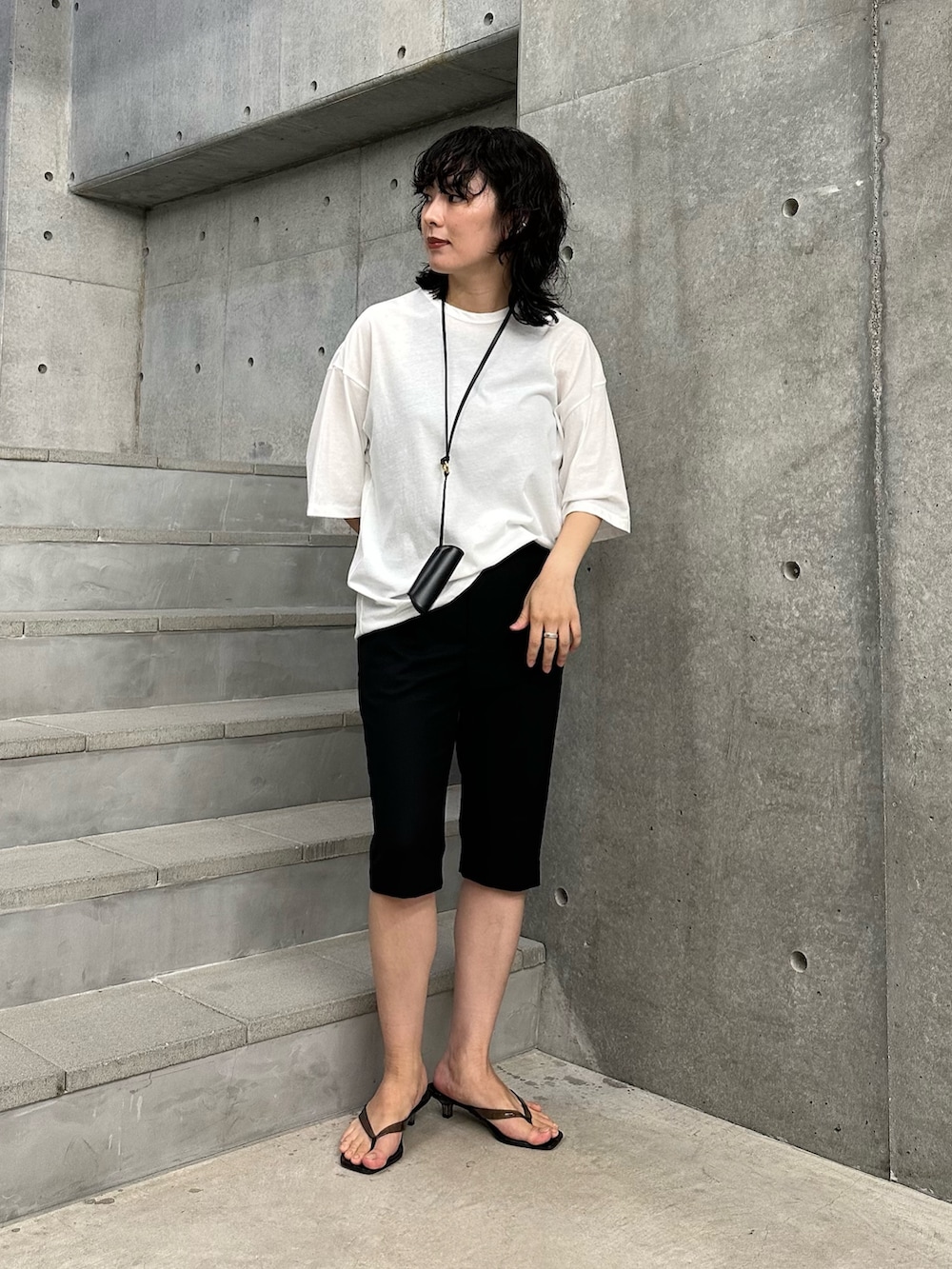 ホワイト系のTシャツ/カットソー、ブラック系のその他パンツ、ブラック系のサンダルを着用したレディースの夏コーディネートの2枚目の写真