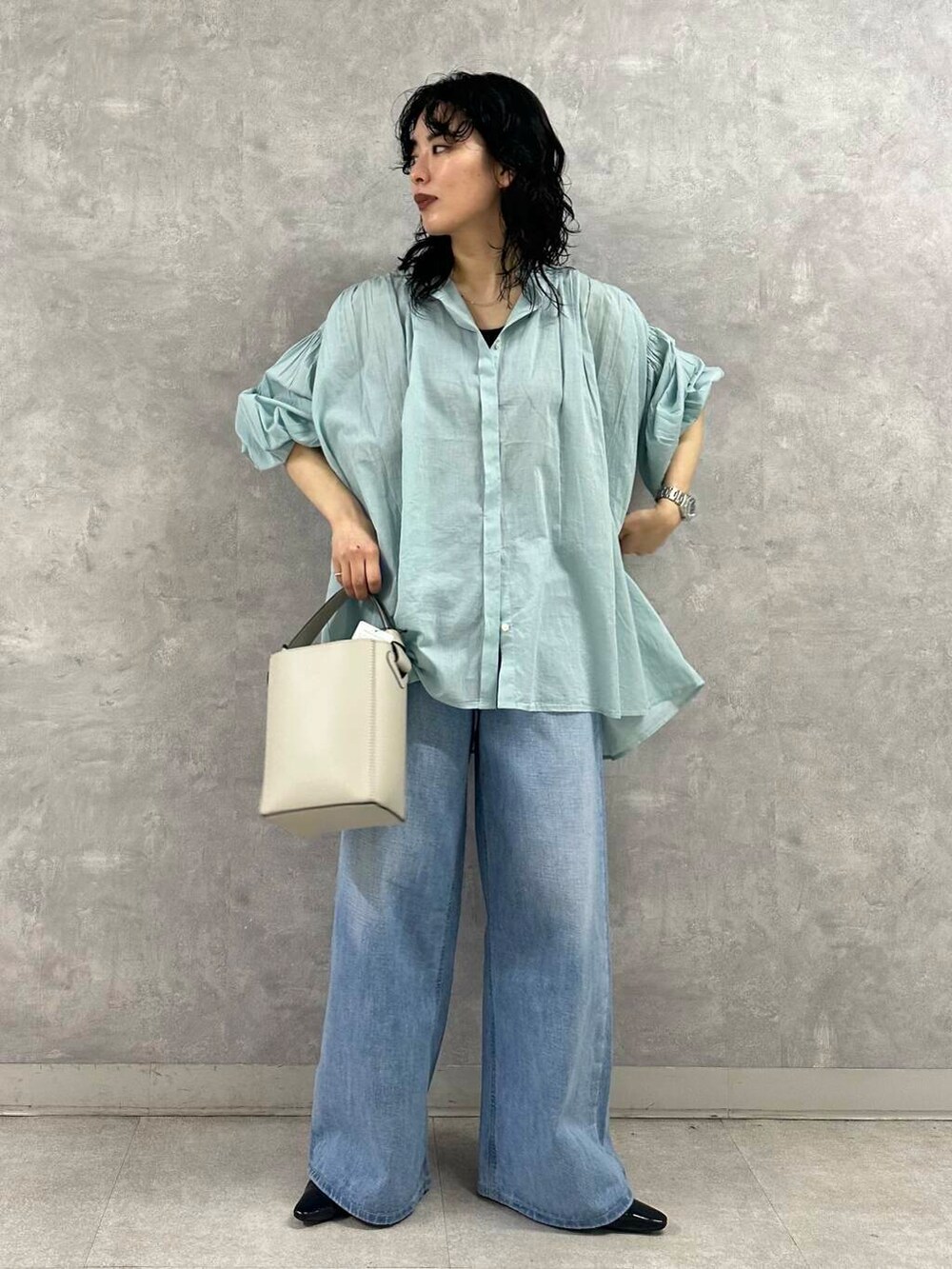 ブルー系のデニムパンツ、ホワイト系のトートバッグ、グリーン系のシャツ/ブラウスを着用したレディースの春コーディネートの3枚目の写真