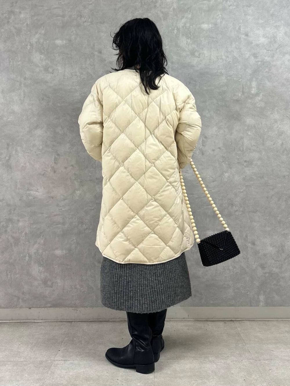 ホワイト系のダウンジャケット/コート、グレー系のワンピース、ブラック系のショルダーバッグを着用したレディースの冬コーディネートの3枚目の写真