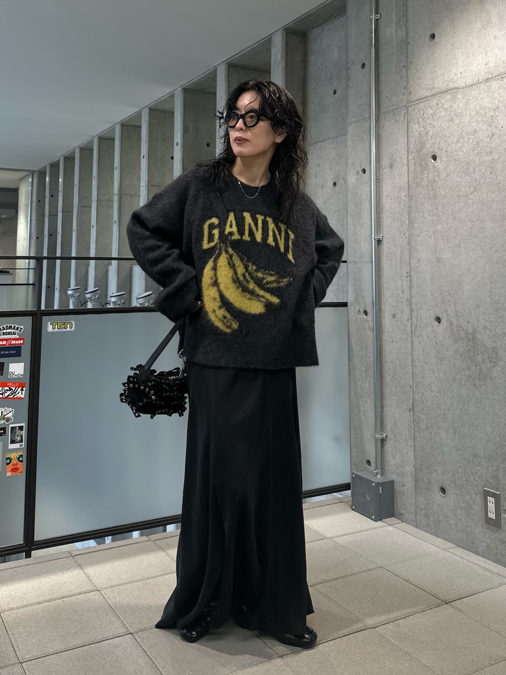 グレー系のニット/セーター、ブラック系のスカート、ブラック系のチャームを着用したレディースの夏コーディネートの2枚目の写真