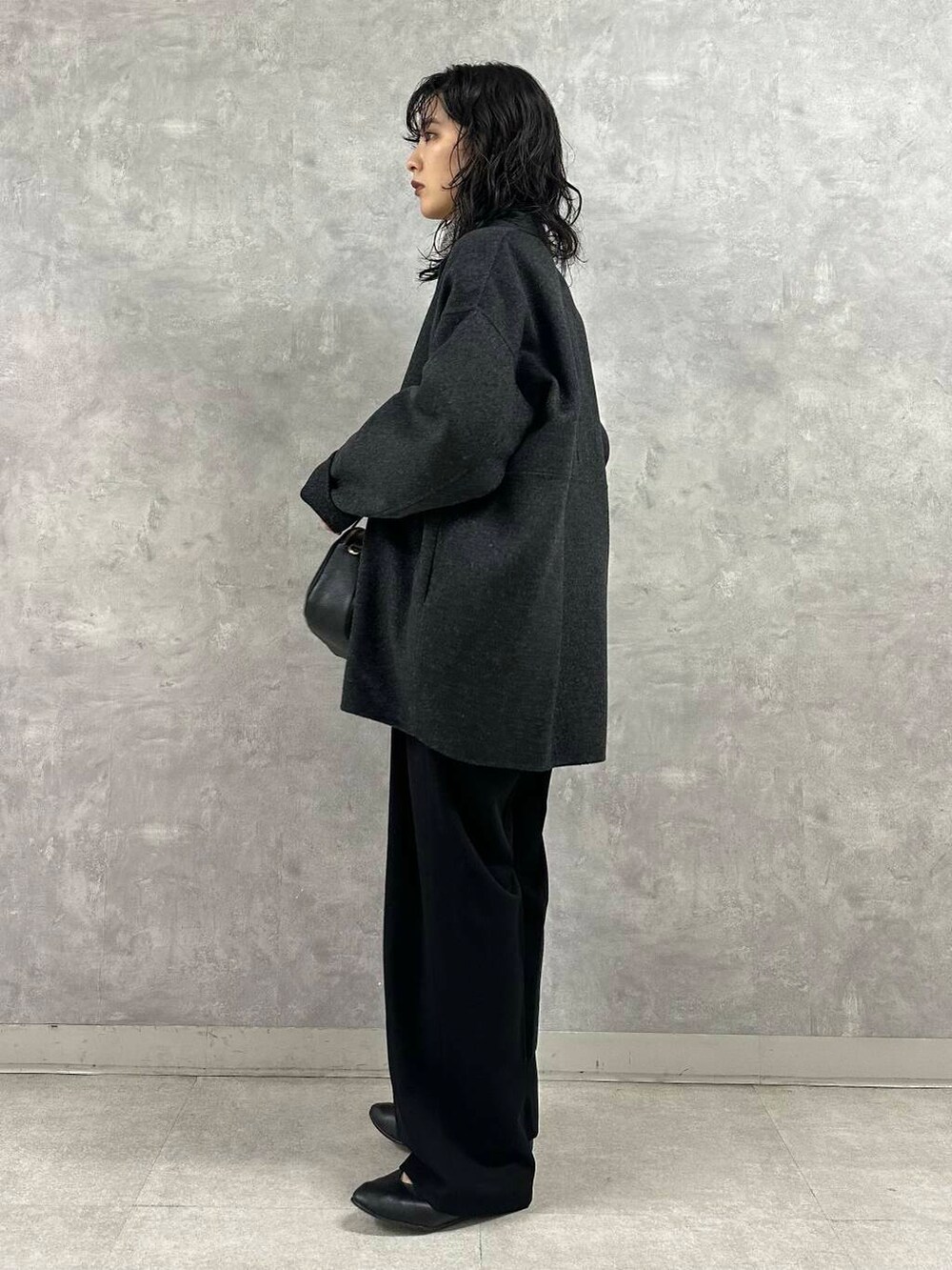 グレー系のその他アウター、ブラック系のニット/セーター、ブラック系のショルダーバッグを着用したレディースの冬コーディネートの3枚目の写真