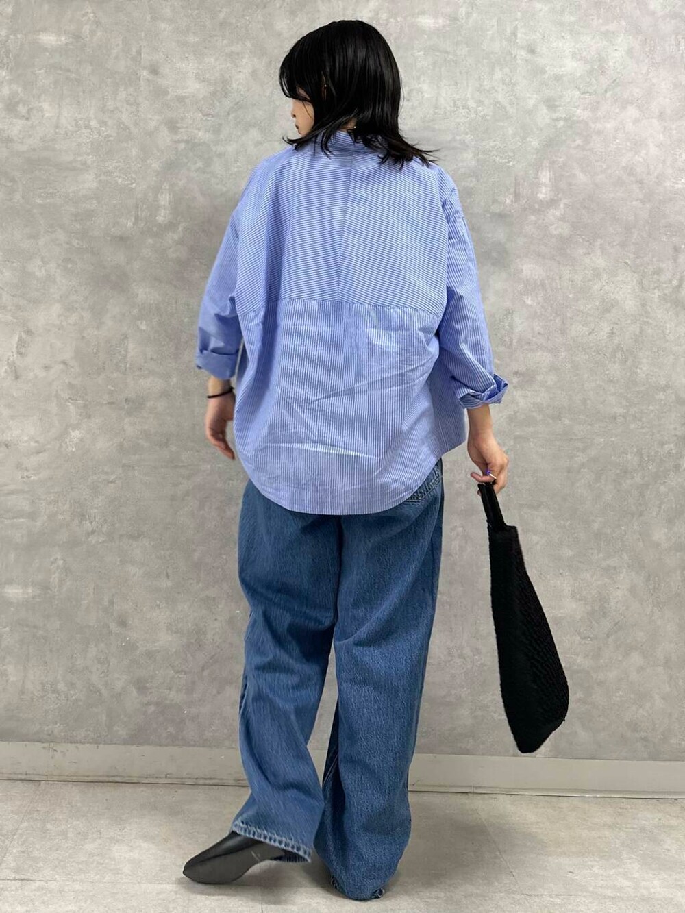 ホワイト系のタンクトップ、ブルー系のデニムパンツ、ブラック系のトートバッグを着用したレディースの夏コーディネートの4枚目の写真