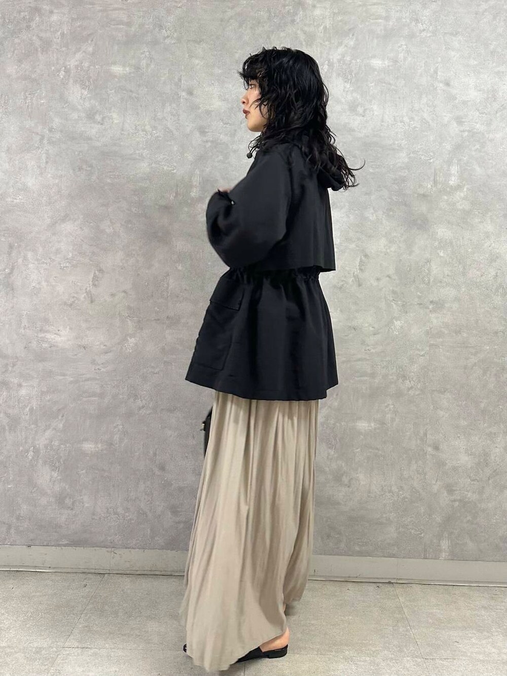 ブラック系のマウンテンパーカー、ブルー系のニット/セーター、ブラック系のショルダーバッグを着用したレディースの春コーディネートの3枚目の写真