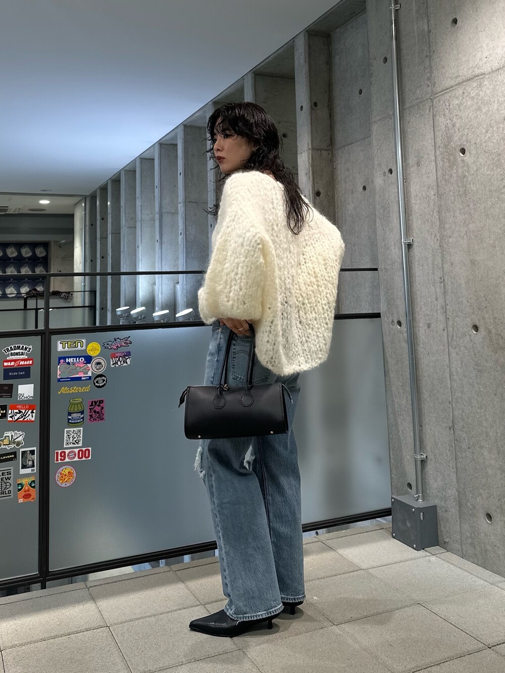 ホワイト系のニット/セーター、ブルー系のデニムパンツ、ブラック系のブーツを着用したレディースの秋コーディネートの2枚目の写真