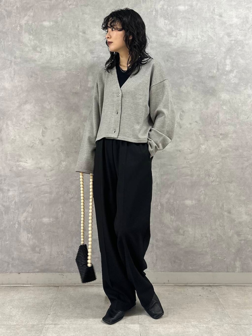 ブラック系のその他パンツ、グレー系のカーディガン/ボレロ、ブラック系のショルダーバッグを着用したレディースの冬コーディネートの2枚目の写真