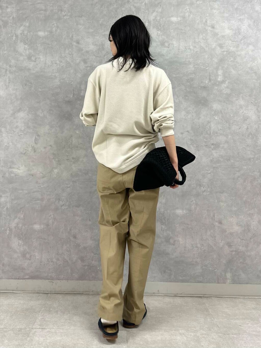 ブラック系のトートバッグ、ベージュ系のその他パンツ、ホワイト系のTシャツ/カットソーを着用したレディースの秋コーディネートの3枚目の写真